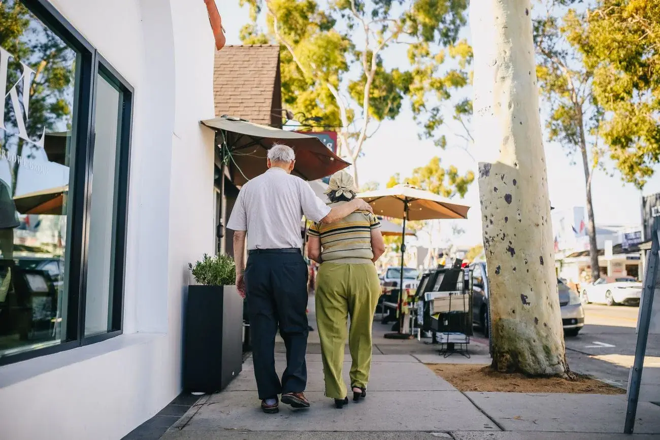 Two adults enjoying a sunny walk together, illustrating everyday life
