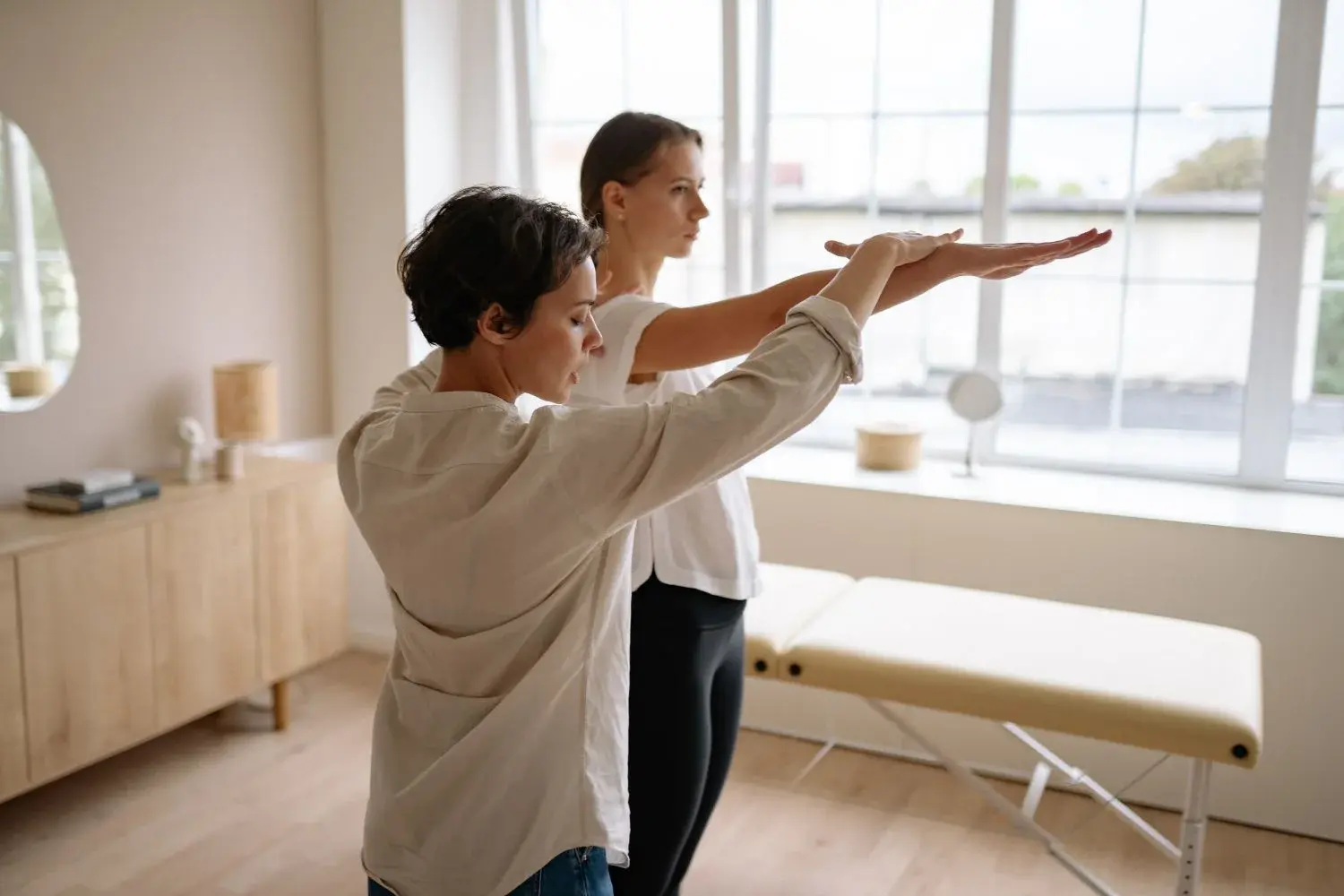 A therapist guiding a person's movement in an illustrative rehabilitation session
